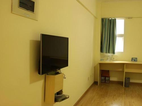 a living room with a flat screen tv on a wall at 7 Days Inn Chengdu North Railway Metro Station in Chengdu