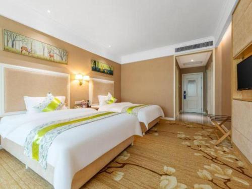 a hotel room with two beds and a flat screen tv at Catic Hotel--Adjacent Buliding in Zhuhai