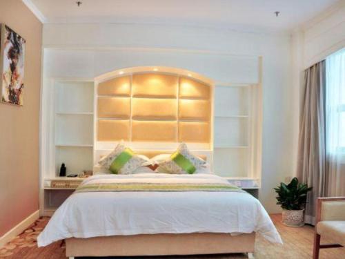 a bedroom with a large bed with a large headboard at Catic Hotel--Adjacent Buliding in Zhuhai