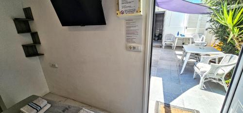 a door leading to a patio with a table and chairs at Pleasure Black Beach Perissa Santorini in Perissa