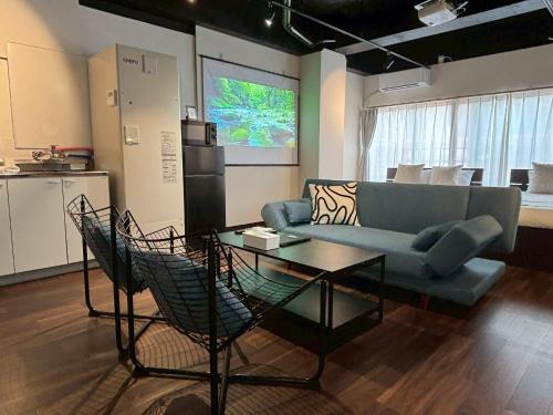 a living room with a couch and a table at Neighbor's Hotel 西広島駅前 in Hiroshima