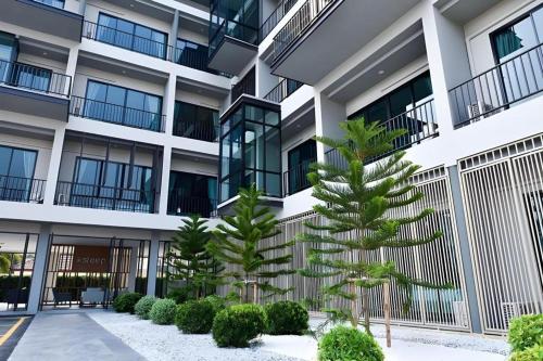 an apartment building with two trees in the courtyard at @Sleep in Nakhon Pathom