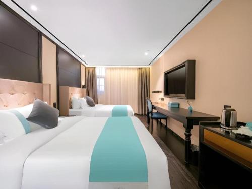 Duży pokój hotelowy z 2 łóżkami i biurkiem w obiekcie Xana Hotelle Jinan Daminghu North Gate w mieście Jinan