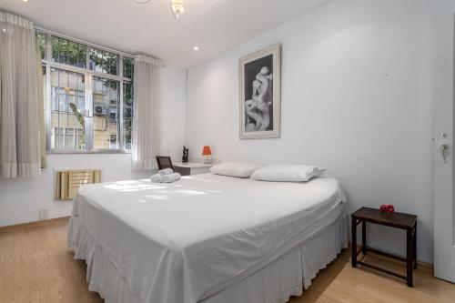 a white bedroom with a large bed and a window at Espaçoso - Charme House - Copacabana in Rio de Janeiro