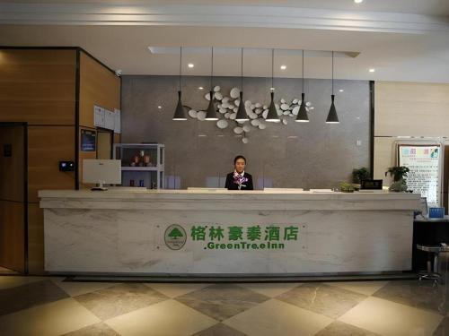 a person standing behind a counter in an office at GreenTree Alliance Hotel Lhasa Potala Palace Norbulingka in Lhasa