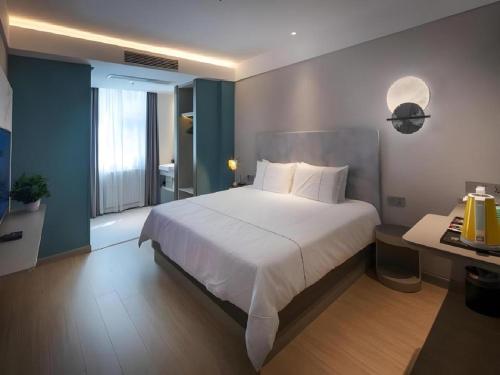 Postel nebo postele na pokoji v ubytování Magnotel Hotel Shiyan Wuyan Pedestrian Street