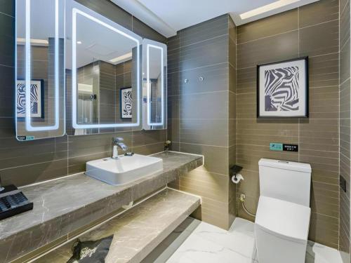鄭州市にあるXana Hotelle Zhengzhou North Passenger Terminal North University Townの洗面台とトイレ付きのバスルーム