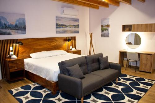a bedroom with a bed and a couch and a desk at Nubária Residences in San Pablo Etla