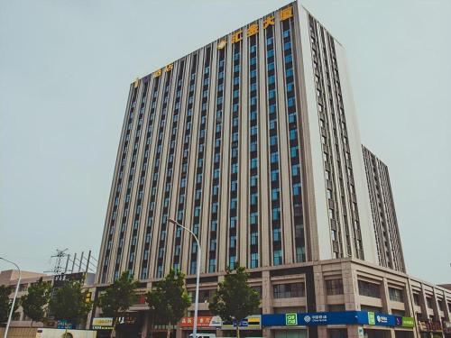 a tall building with a lot of windows on it at IU Hotel·Weifang High-tech Zone Huijin Tower in Weifang