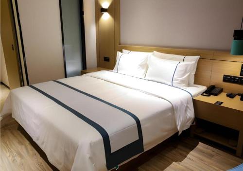 a large white bed in a hotel room at City Comfort Inn Wuhan Ikea in Wuhan