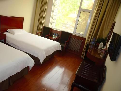 a hotel room with two beds and a window at GreenTree Inn WeiFang QingZhou Middle HaiDai Road Electric Power Shell in Weifang