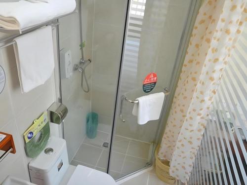 a bathroom with a shower and a toilet at GreenTree Inn WeiFang QingZhou Middle HaiDai Road Electric Power Shell in Weifang