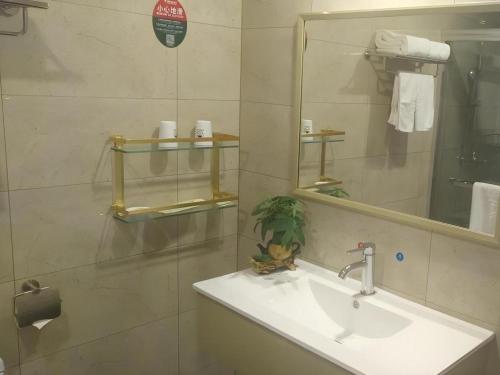 a bathroom with a sink and a mirror at GreenTree Inn Zhanjiang Haitian Bus Station in Zhanjiang