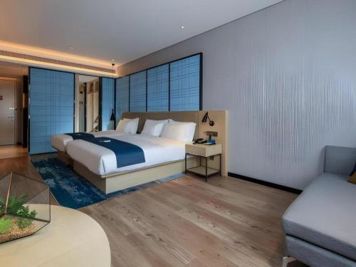 ein Schlafzimmer mit einem großen Bett und einer Couch in der Unterkunft Echarm Hotel Kunming Railway Station Huancheng South Road Metro Station in Kunming