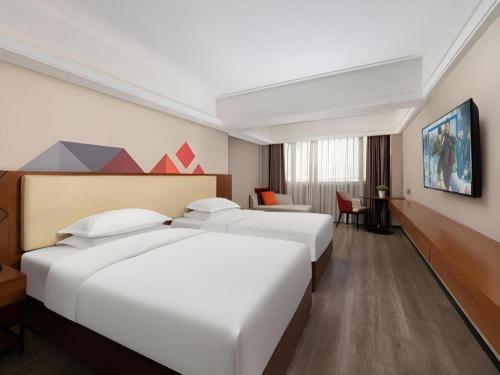 a hotel room with two beds and a desk at Borrman Hotel Guangzhou Railway Station Sanyuanli Metro Station in Guangzhou