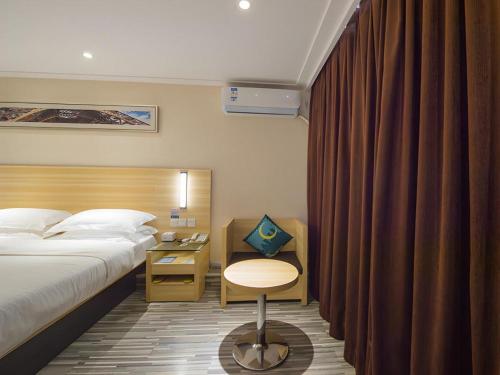 a bedroom with a bed and a desk with a chair at City Comfort Inn Wuhan Guanggu Software Park in Wuhan
