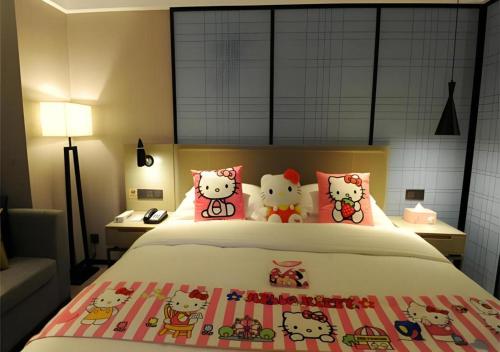 a bedroom with a bed with four hello kitty pillows at Echarm Hotel Nanning Chaoyang Square River View in Nanning