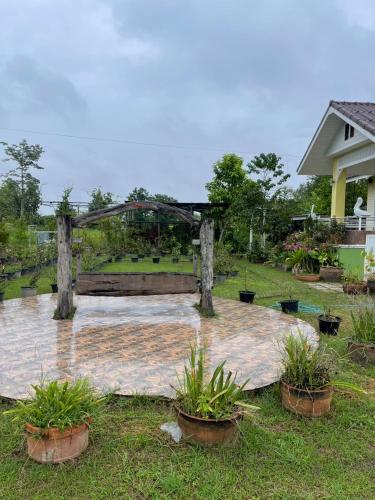 a garden with a wooden arch and potted plants at Ray's in Ban Phae Buak Ha
