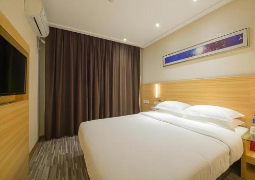 a large white bed in a hotel room at City Comfort Inn Wuhan Guanggu Textile University in Wuhan