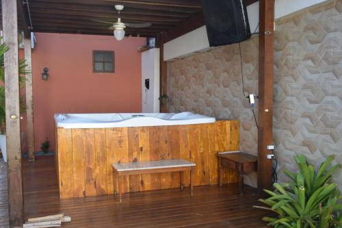 a bath tub in a room with a wooden wall at Pousada Liberal Liberte-se in Búzios- Somente Adultos in Búzios