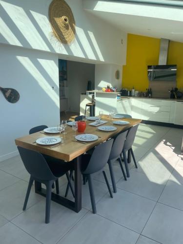 une table en bois dans une cuisine avec des chaises autour de celle-ci dans l'établissement l'Herbo' MAGNIFIQUE maison à 2 pas du porte de Pêche de l'Herbaudière, à LʼHerbaudière