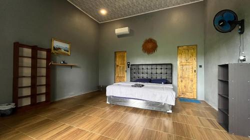 a bedroom with a bed and a wooden floor at AK's Surf Resort in Wainapal