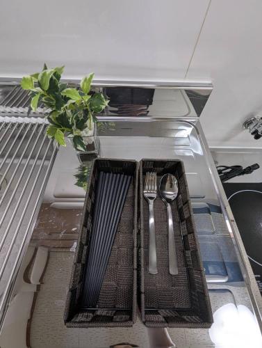 an empty refrigerator with forks and spoons and a plate and knife and fork at Doggo Inn ベッド4台でゆったり宿泊 新潟駅徒歩7分 コンビニ徒歩1分 ペットと泊まれる宿 in Niigata