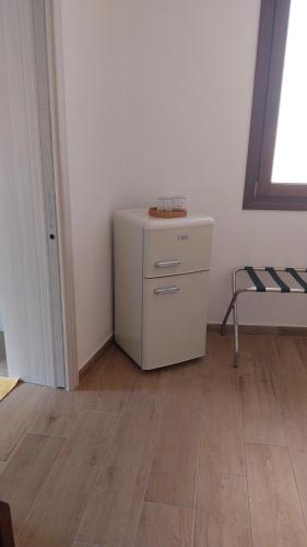 a small white cabinet in a room with a wooden floor at Affittacamere BaLu in Guspini