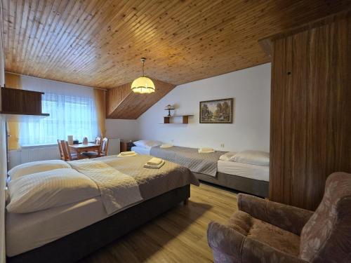 una camera da letto con due letti, un tavolo e una sedia di Pensjonat Duet Mielno 300 metrów od morza a Mielno