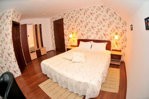 a bedroom with a large white bed in a room at Pensiunea Recanto in Fundata