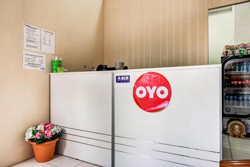 a white refrigerator with a red oo sign on it at OYO 90949 Apartement Cibubur Village kaisar property Lobby B in Pedurenan Dua