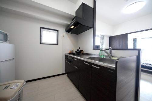 a kitchen with a sink and a refrigerator at Exsaison OKINAWA in Itoman