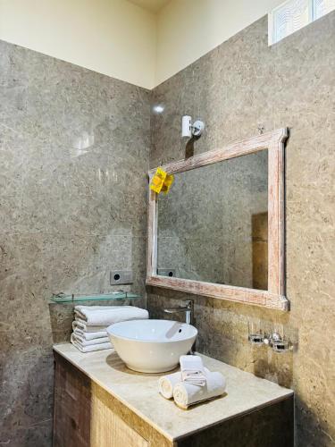 a bathroom with a sink and a mirror at Two Brothers Bungalows in Gili Meno