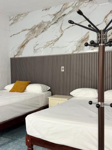 a hotel room with two beds and a microphone at Hotel Naturaleza Bacalar- Gratis bicibletas in Bacalar