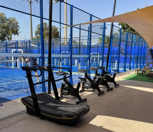 a group of treadmills in a gym with a large window at Odyssee Park Hotel in Agadir