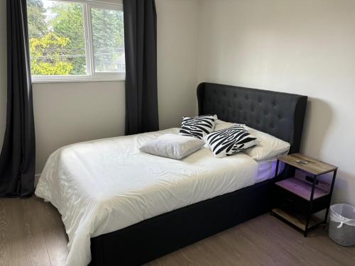 a bed with two pillows on it in a bedroom at Cozy 3-Bedroom Retreat in Surrey Share Save in Surrey