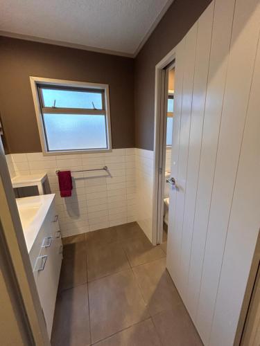 a bathroom with a sink and a window at Mount golf & beach retreat in Mount Maunganui