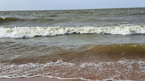 two waves in the ocean on a sandy beach at Casa de Praia Guajarino - COP 30 in Barcarena