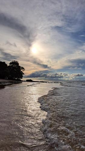 a view of the ocean with the sun shining at Casa de Praia Guajarino - COP 30 in Barcarena