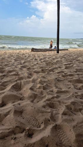 a person sitting on a beach near the ocean at Casa de Praia Guajarino - COP 30 in Barcarena
