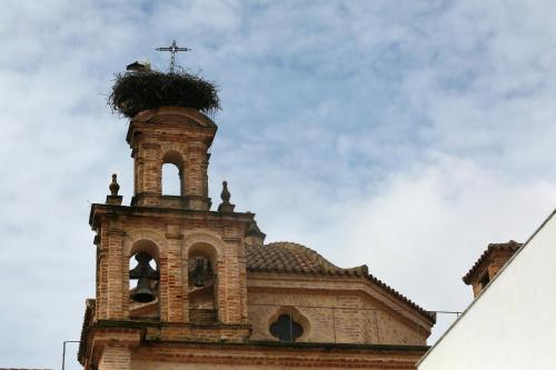 
a tall building with a clock on the top of it at Hotel Convento Aracena & SPA in Aracena

