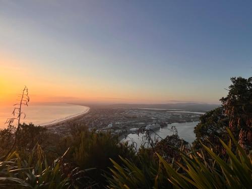 a view of the beach at sunset from a mountain at Mount golf & beach retreat in Mount Maunganui
