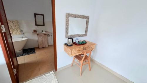 a bathroom with a table with a mirror and a sink at Uma Luwih Villa in Ubud