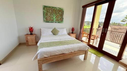 a bedroom with a bed and a balcony at Uma Luwih Villa in Ubud
