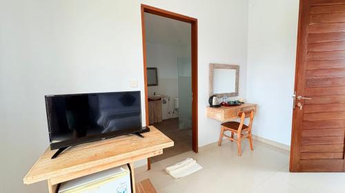 a living room with a flat screen tv on a table at Uma Luwih Villa in Ubud