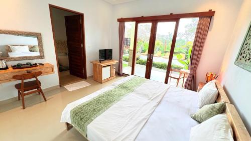 a bedroom with a bed and a desk and a window at Uma Luwih Villa in Ubud