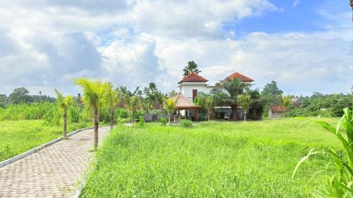 a house in the middle of a green field at Uma Luwih Villa in Ubud