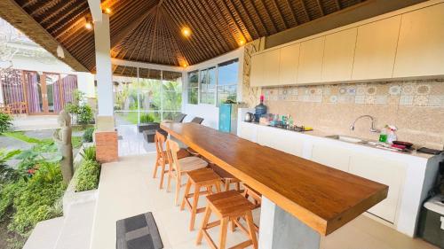 an open kitchen with a large wooden table in a house at Uma Luwih Villa in Ubud
