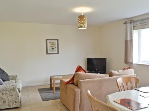 a living room with a couch and a table at Hornbeam Cottage in Great Malvern