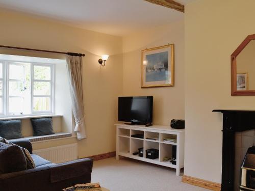 un soggiorno con TV e finestra di Barton Cottage a North Petherwin
